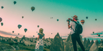 Man taking photo of hot air balloons